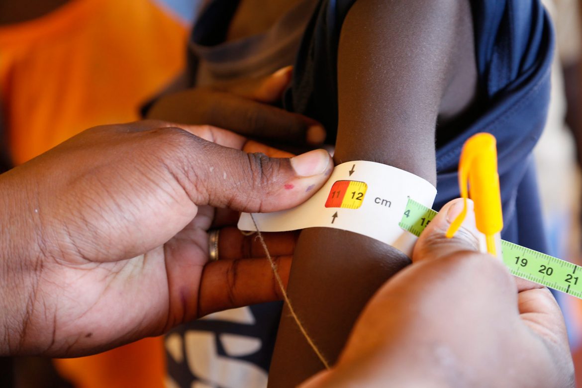 A health care worker measures a child’s arm as part of a malnutrition screening programme at a health clinic in Kenya. Humanitarian organization