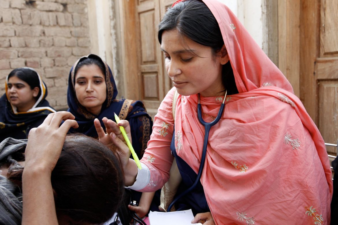 A female doctor examines a women patient at a mobile health clinic in Pakistan.